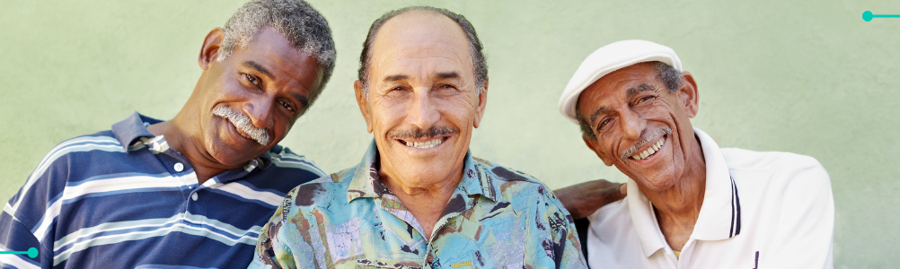 A group of elderly gentlemen smiling towards the camera.